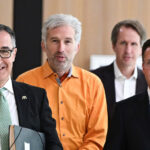 Gruppenbild vor Holzvertäfelung